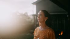 Woman looking up into sunshine