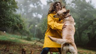 Dog jumping up on woman while they walk in the forest