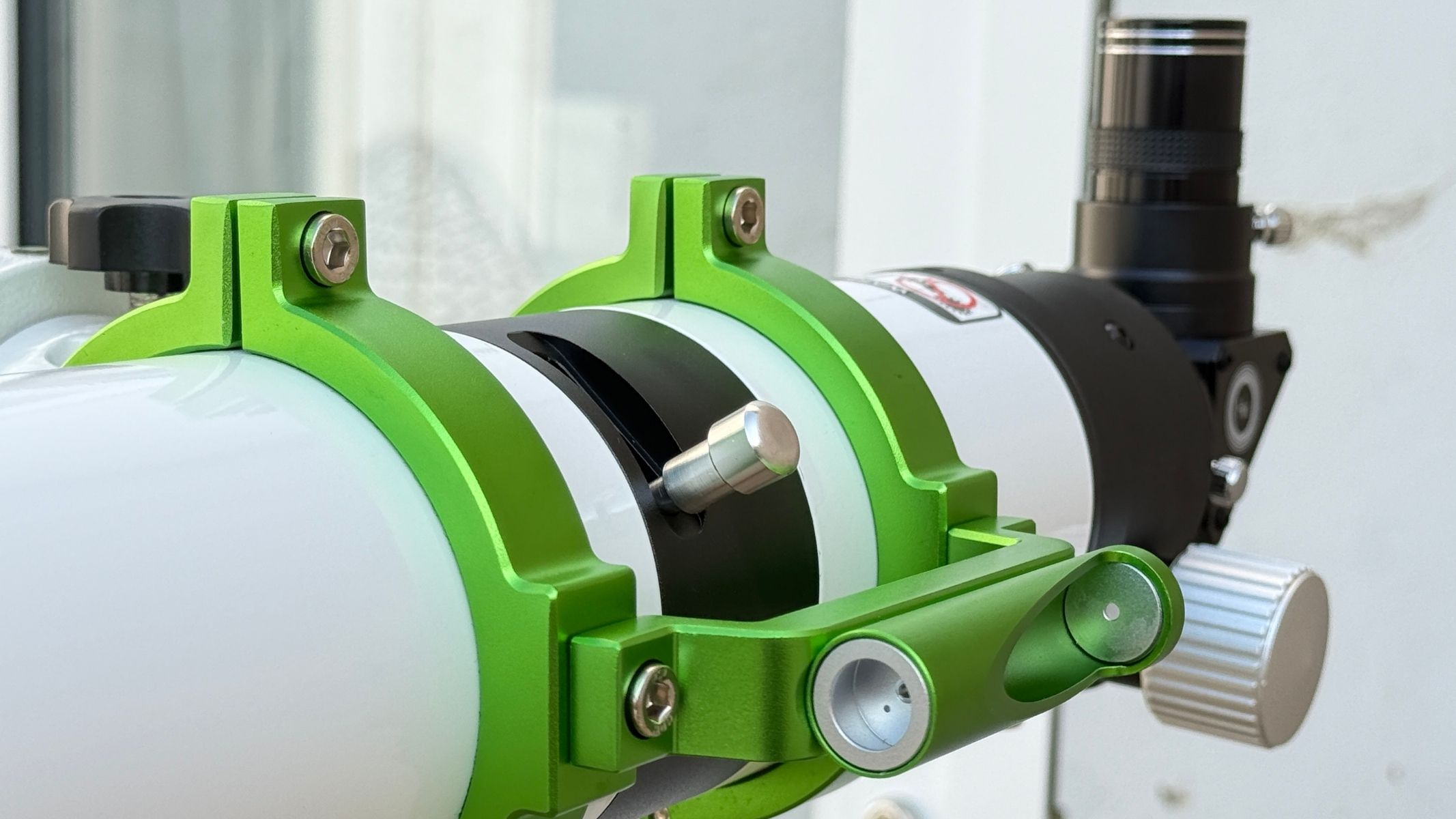 A green metal tuner attached to the optical tube of the Sky-Watcher Heliostar 76mm H-alpha solar telescope.