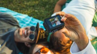 GoPro HERO action camera held up taking a photo of a group of people laying on the ground