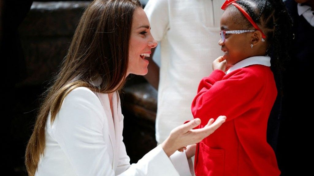 Britain&#039;s Catherine, Duchess of Cambridge, speaks to a girl as they attend the unveiling of the National Windrush Monument at Waterloo Station in London on June 22, 2022