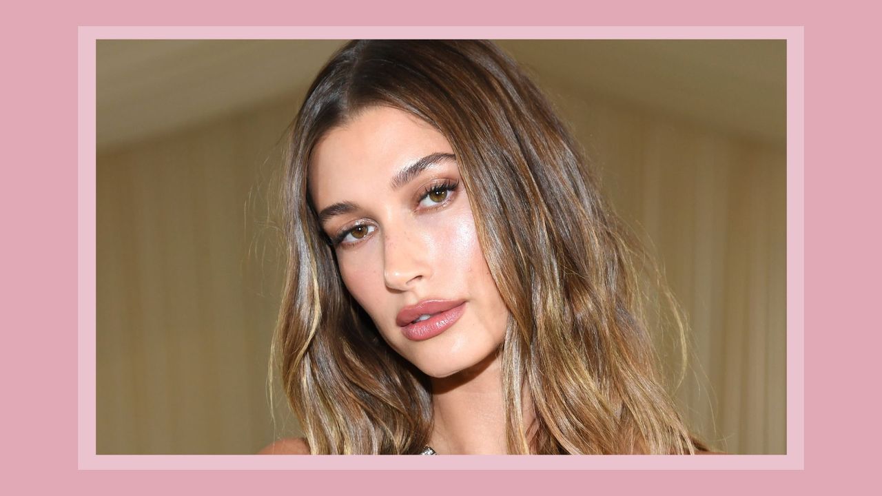 Hailey Bieber with soft, natural-looking makeup and mascara (taken at The 2021 Met Gala) / on a pink background