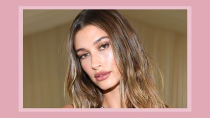 Hailey Bieber with soft, natural-looking makeup and mascara (taken at The 2021 Met Gala) / on a pink background