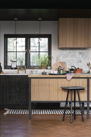 a black wood panelled kitchen with a wood freestanding island