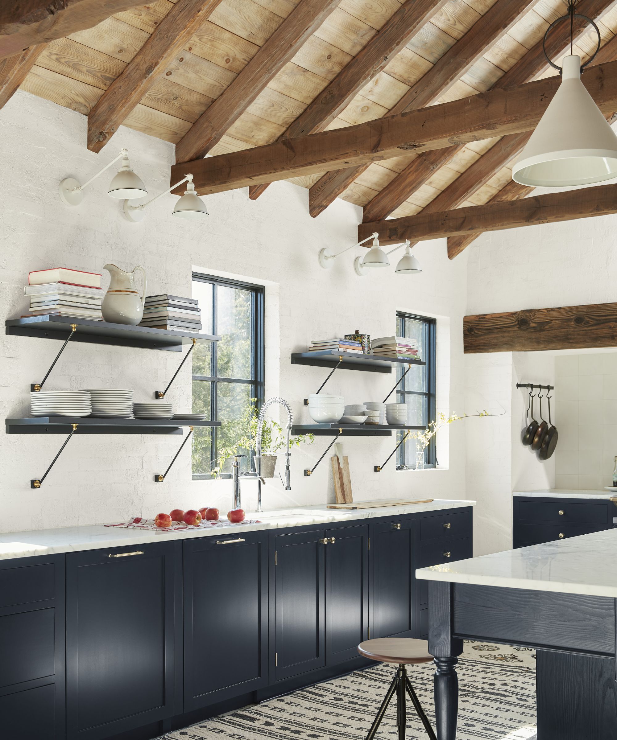 A tri-color kitchen with dark blue cabinets, white walls, and a wooden ceiling