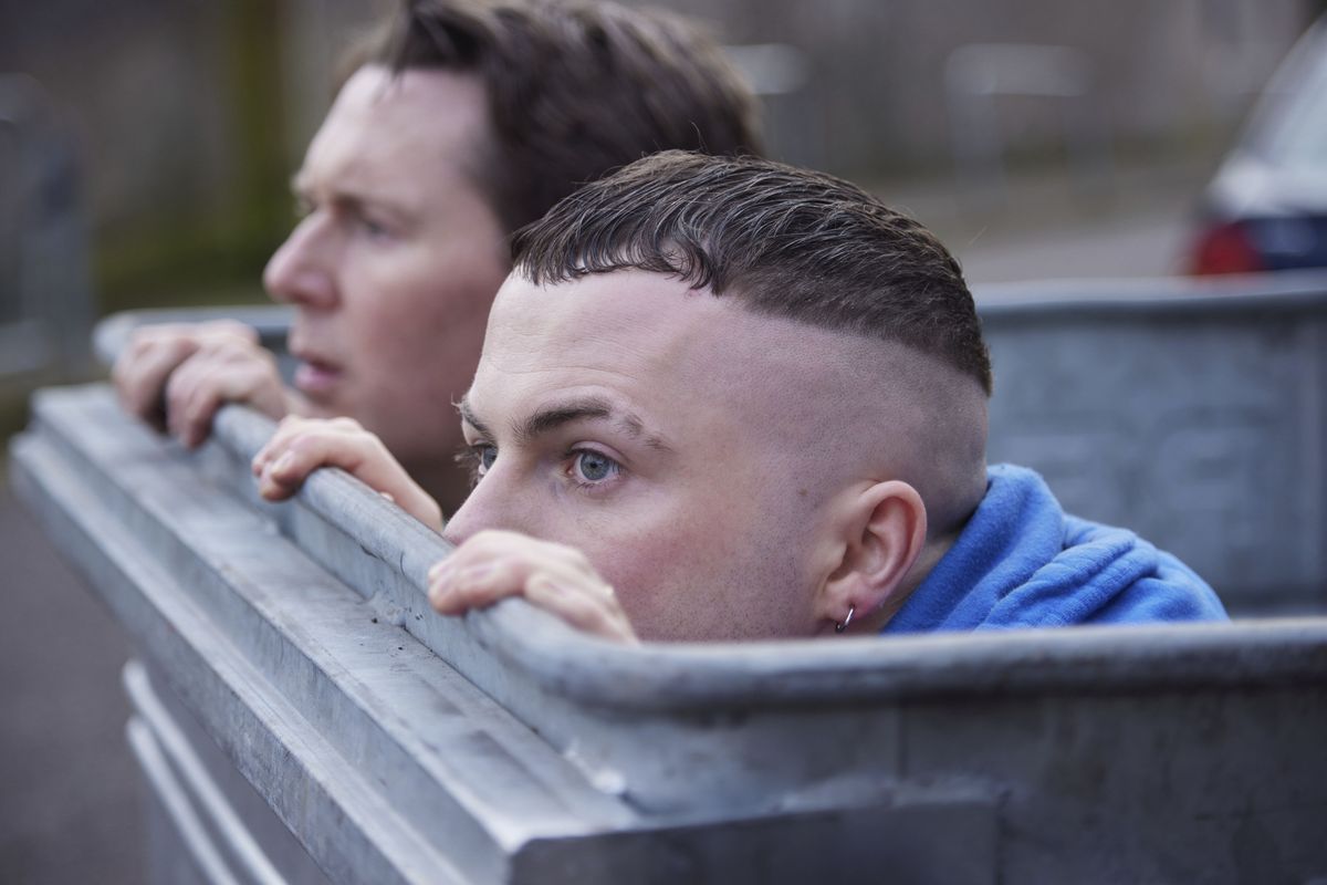 The Young Offenders season 4 stars Shane Casey and Alex Murphy in character as Billy and Conor hiding in a bin. 