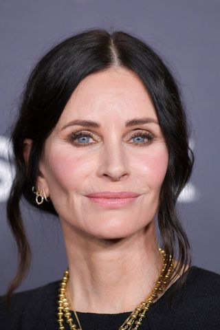 Courteney Cox is pictured with a wispy bun as she attends the premiere of STARZ "Shining Vale" at TCL Chinese Theatre on February 28, 2022 in Hollywood, California.
