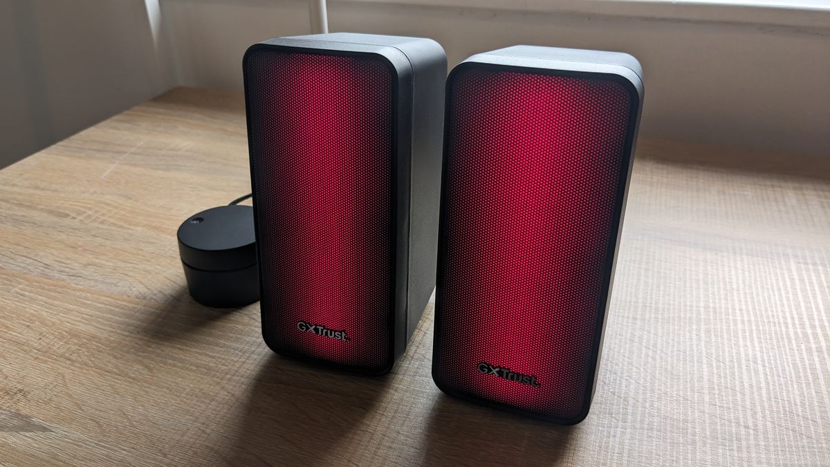The Trust GXT 611 Wezz RGB speakers pictured on a wooden desk.