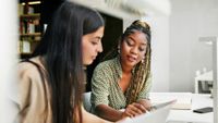 two students working together in a library