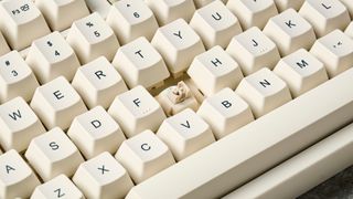 The Lofree Block keyboard on a stone surface with a blue wall in the background.