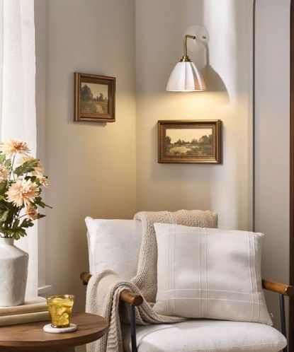 Living room nook with Cream armchair with overhead lighting and vase with flowers