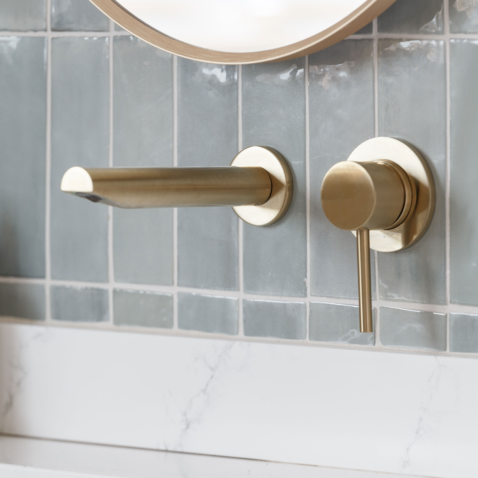 Close up of gold tap on bathroom wall