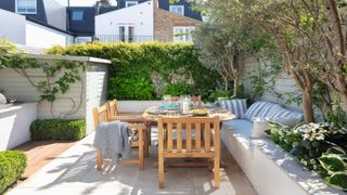 Narrow garden with seating, wood furniture and shrubbery