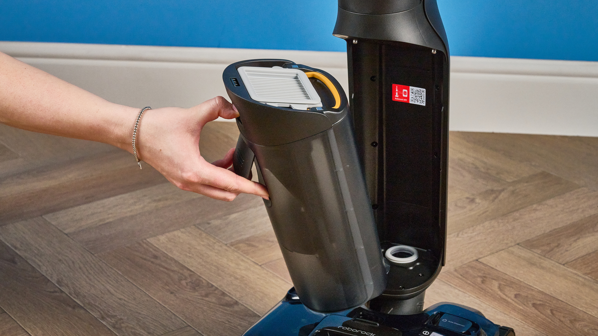 Dirty water tank of the Roborock F25 ACE Pro photographed on a brown wood floor