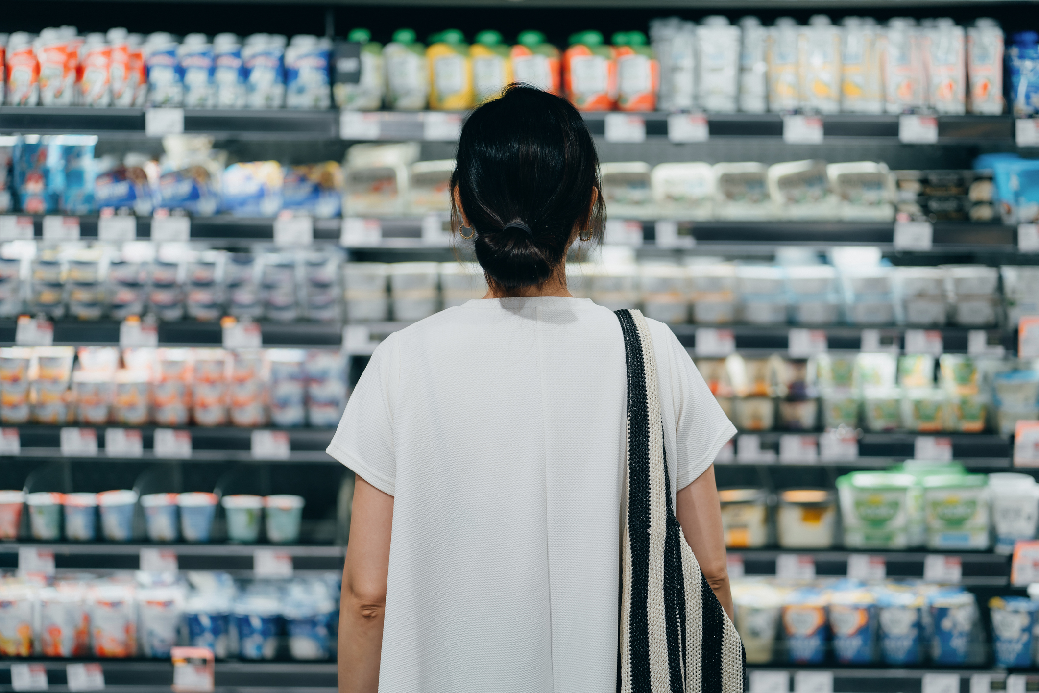 Woman looking at supermarket fridges