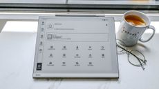 The Onyx Boox Go 10.3 e-paper writing tablet with stylus on a tablet with a cup of tea and glasses