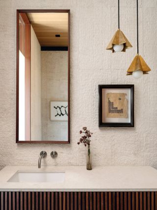 Bathroom close-up with rectangular wood mirror and brass star-shaped pendant lights