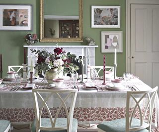A light green dining room with exsentric pink table setting with flowers