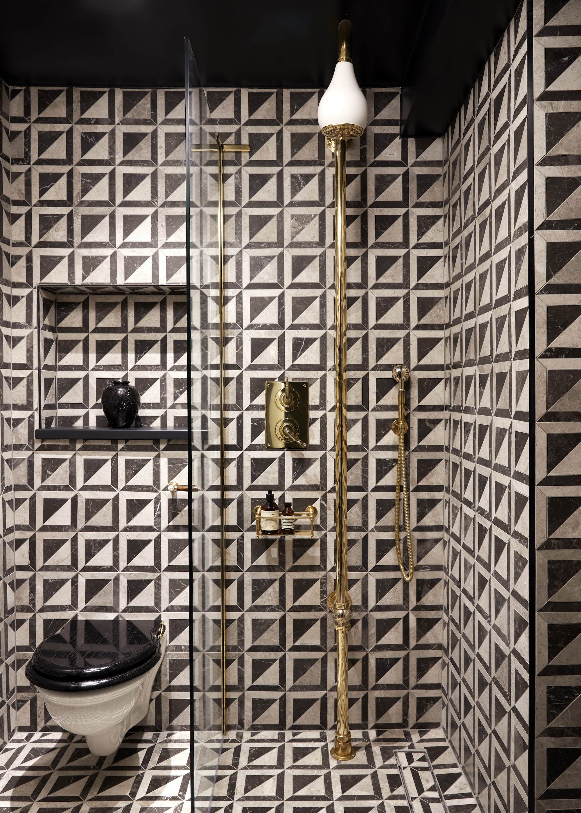 a black and white bathroom with patterned tiles