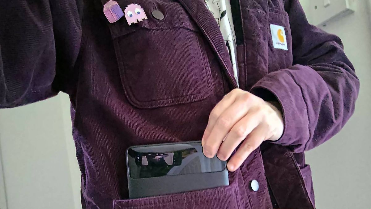 Phil wearing purple Carhartt jacket pulling Baseus Blade power bank out of pocket.