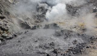 White and gray puffs of sulfur seep out from beneath the ground inside a fumarole in the Campi Flegrei caldera.