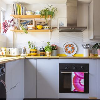 Grey kitchen with yellow worktop and accessories.
