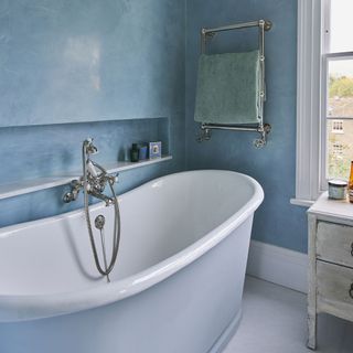 bathroom with blue wall and bathtub