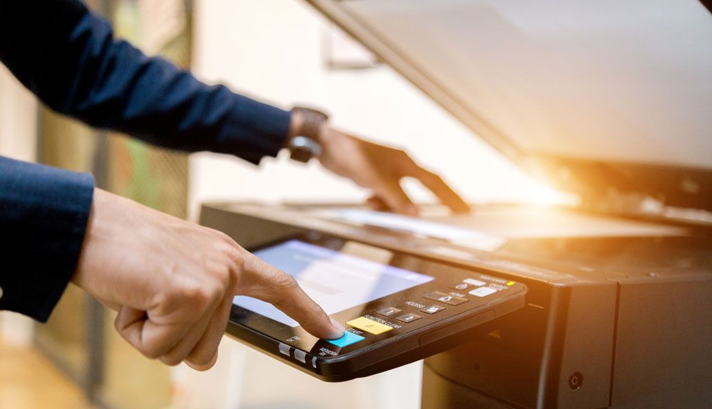 Man&#039;s hands operating office printer.