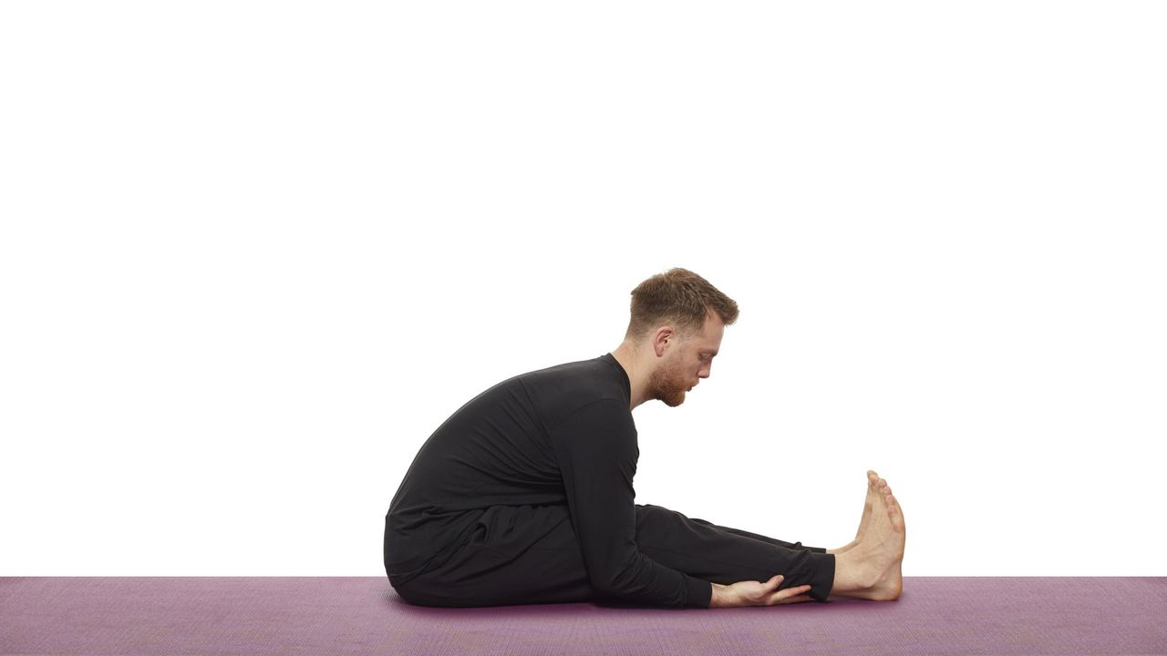 Yoga teacher Nick Higgins performs seated forward bend
