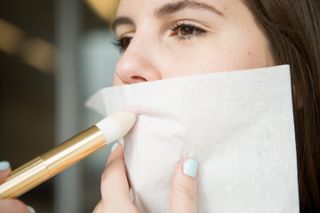 Applying Translucent Powder to Lips Through Tissue