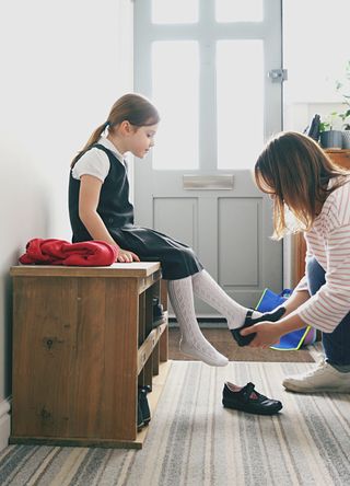 A school pupil putting on shoes