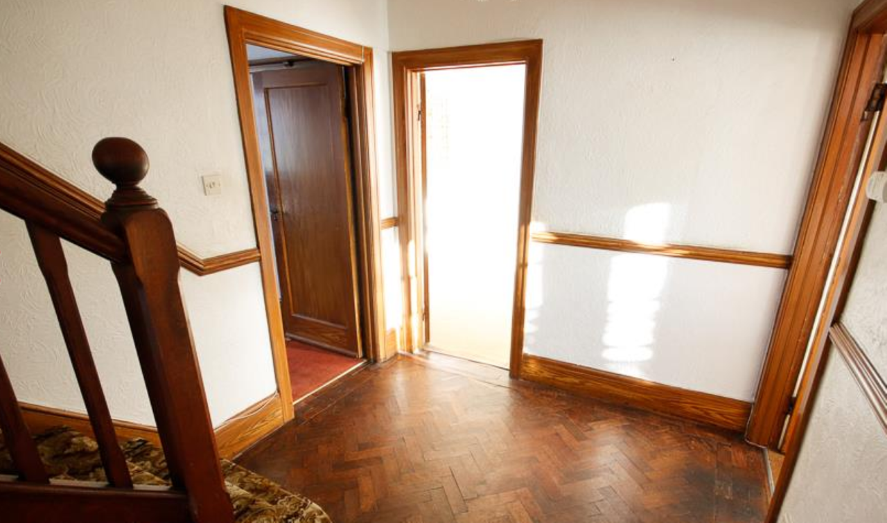 Hallway with herringbone flooring showing leading to the front door