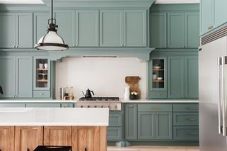 A kitchen with blue green cabinets