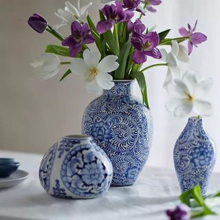 A Terrain Chinoiserie vase filled with purple and white flowers