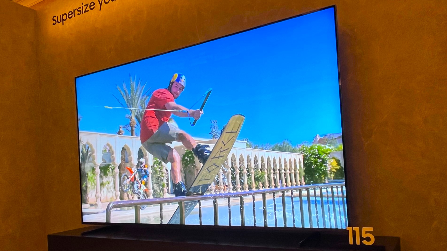 El televisor Samsung QN90F de 115 pulgadas muestra una imagen de una patineta