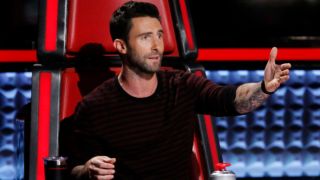 Adam Levine is shown gesturing from the Big Red Chair on The Voice in 2016.