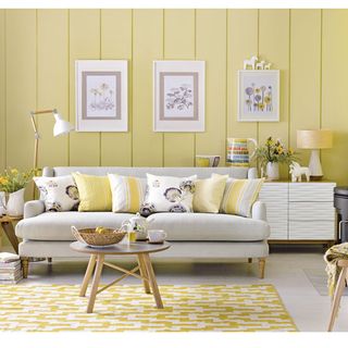 living room with yellow walls sofa and wooden table