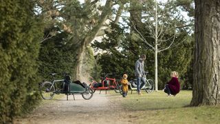 A family with their children in the woods with cargo bikes