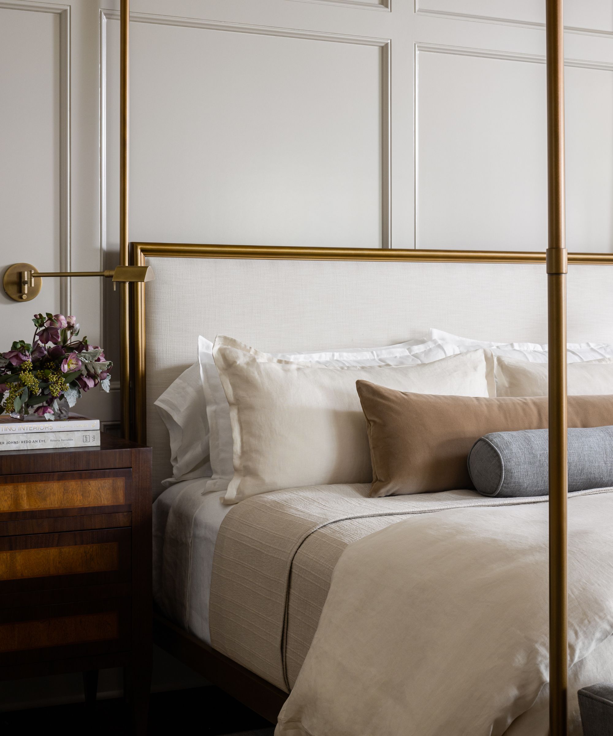bedroom with white panelled wall and neutral bedding