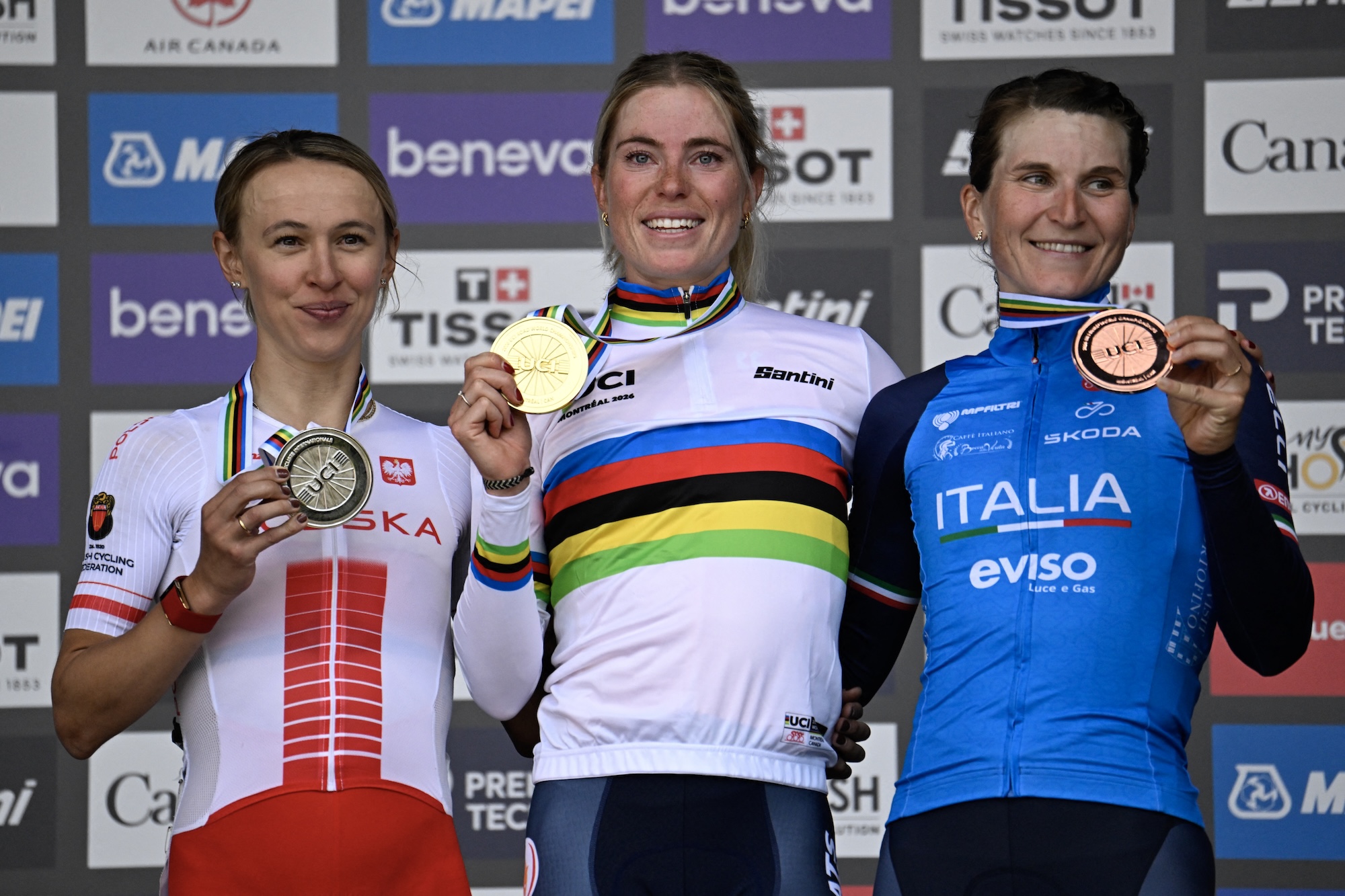 Elite women road race podium at the 2026 UCI Road World Championships: second-place Kasia Niewiadoma-Phinney (Poland), winner Demi Vollering (Netherlands) and third-placed Elisa Longo Borghini (Italy)