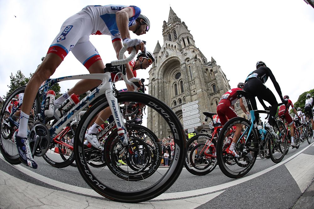 Riders pass the local architecture.