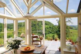 a conservatory with a dining room looking out to a garden