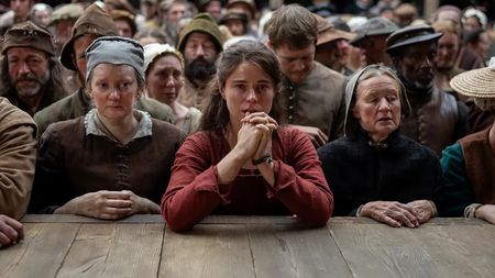 Agnes Shakespeare praying and looking teary-eyed in a crowd in Hamnet
