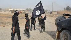Iraqi government forces hold an Islamic State flag after they claimed they controlled an Islamic State town