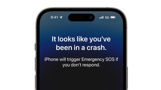 An iPhone 14 Pro with the text 'It looks like you've been in a crash' on the screen