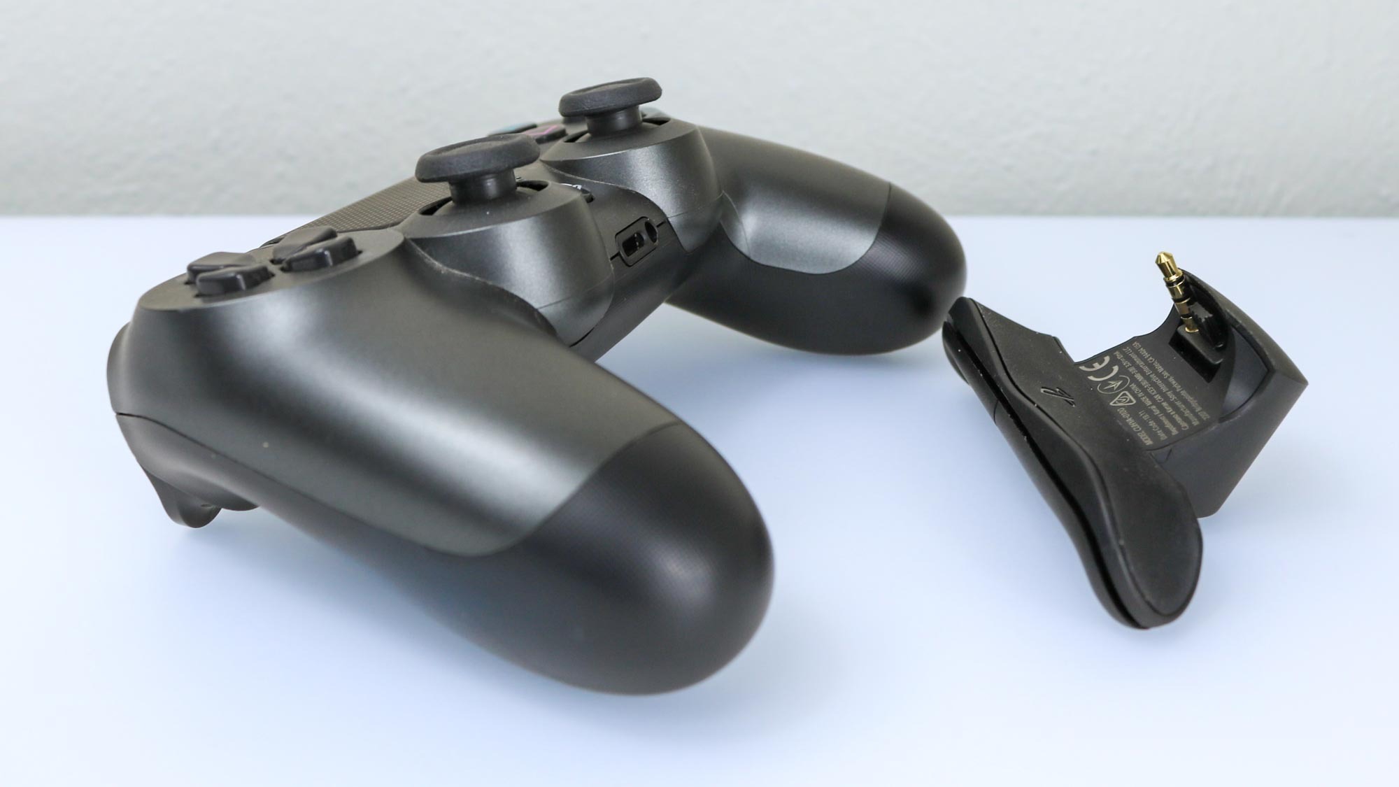The DualShock 4 Back Button Attachment next to a DualShock 4 controller
