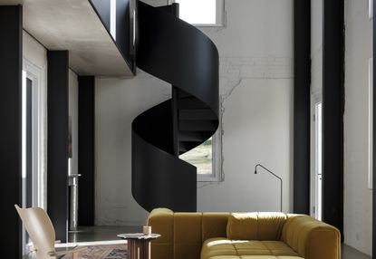 A living room with a spiralling staircase in black