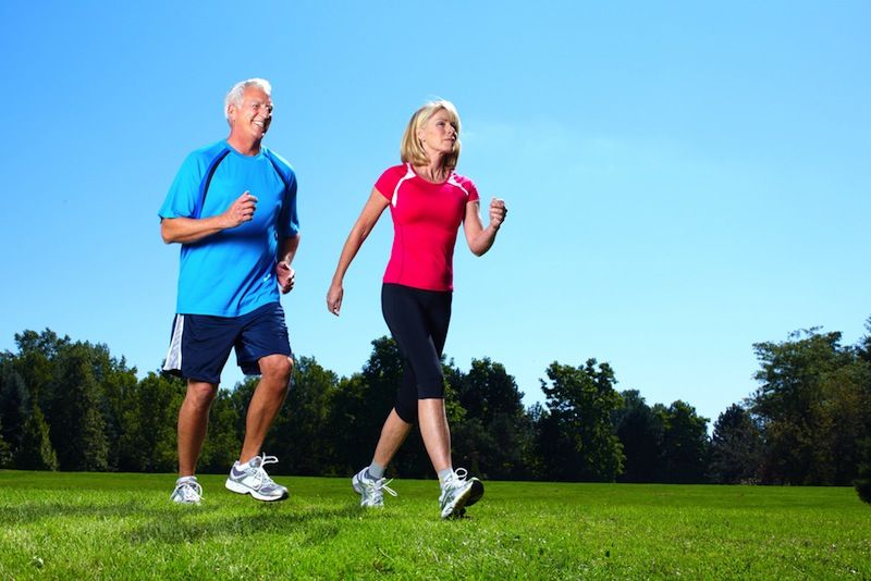 An older couple goes power walking outside