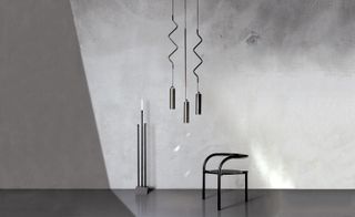 Abstract light fitting, tall candle holder and black chair