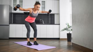 Woman performs reverse flye with dumbbells